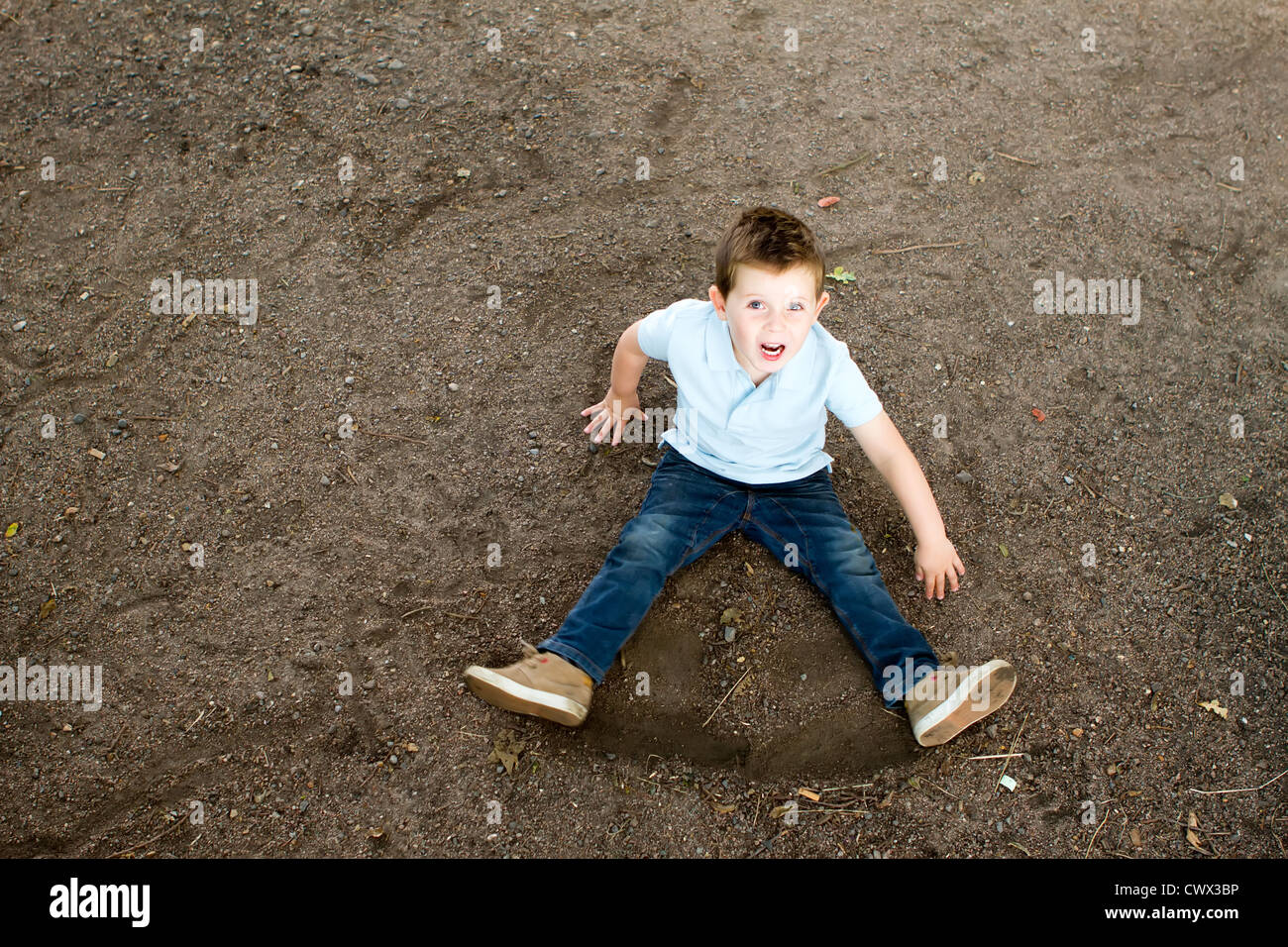 boy sitting on a stony woodland path Stock Photo