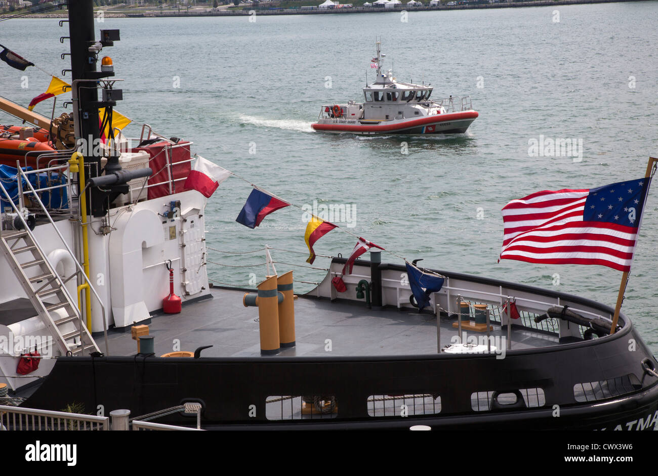 A small Coast Guard patrol boat passes the U.S. Coast Guard cutter Katmai Bay Stock Photo