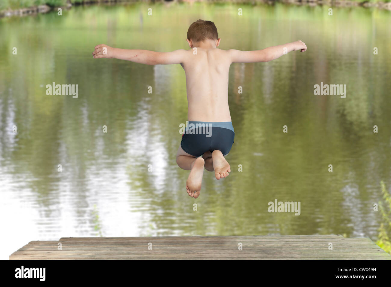 boy jumping in a lake, back view Stock Photo