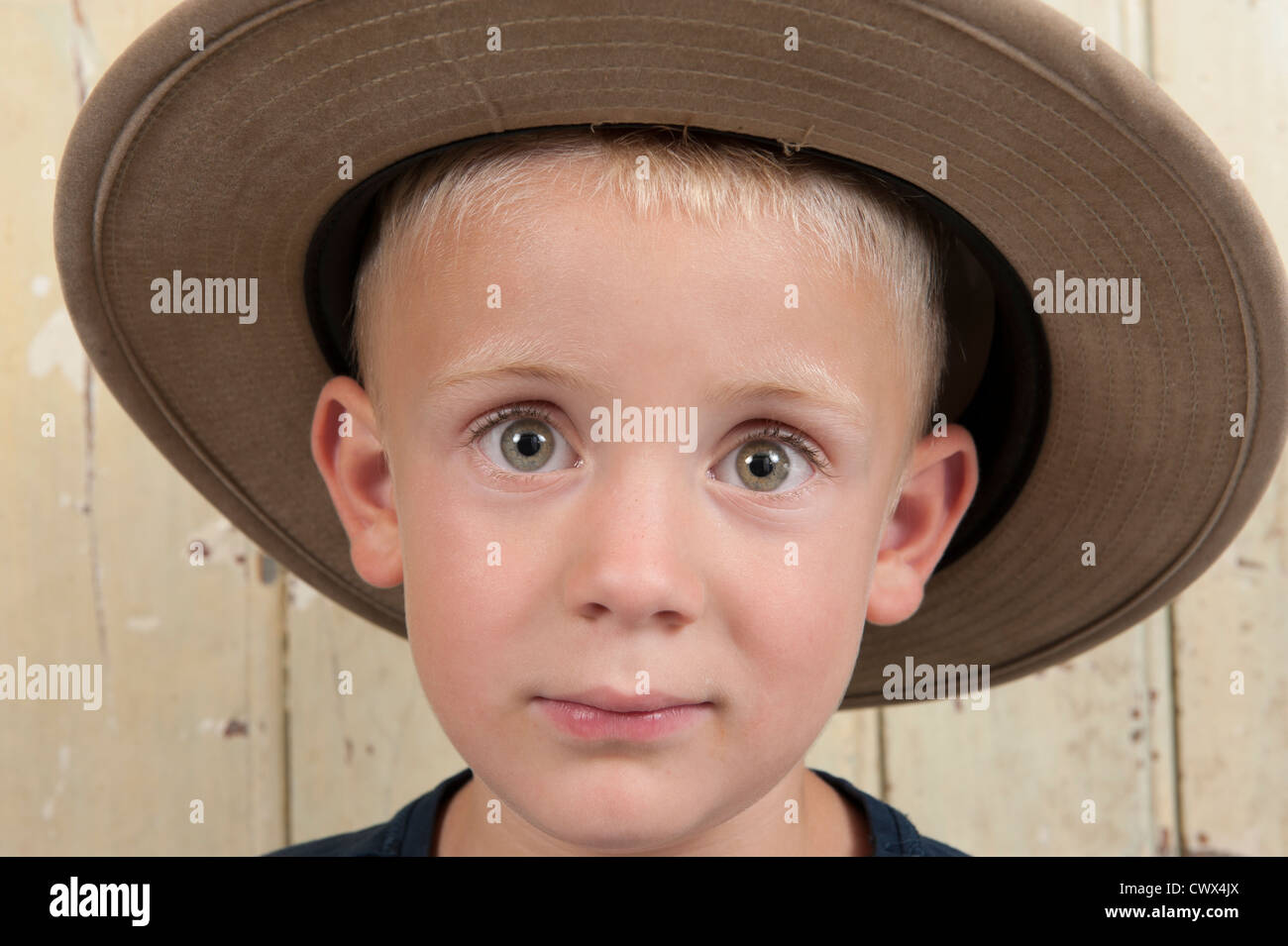 little boy with cowboy hat against an old wooden door Stock Photo Alamy