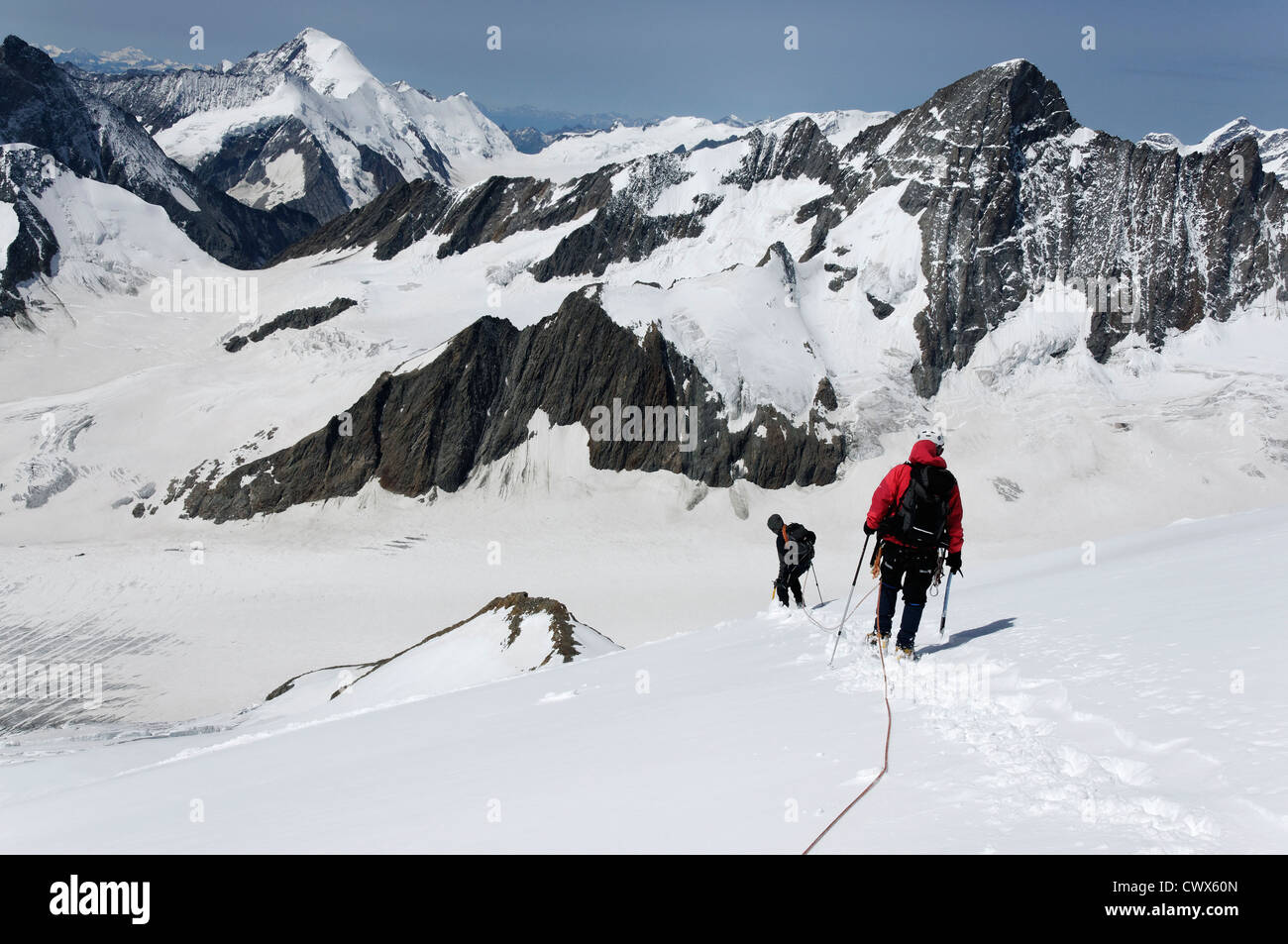 Climbers traveling on a glacier in the Bernese Alps Stock Photo