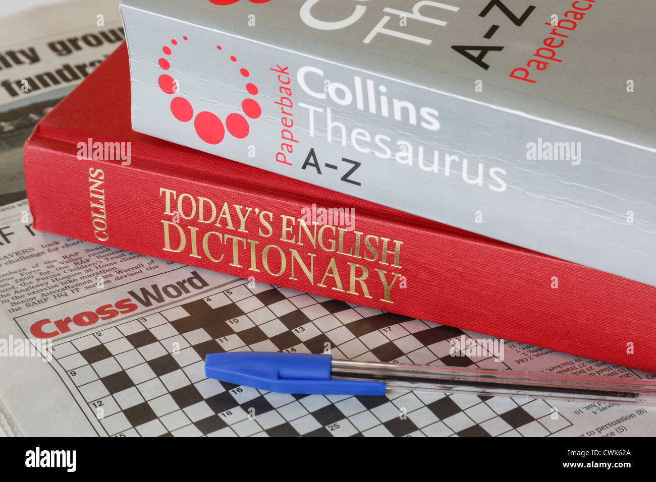 Collins A-Z Thesaurus and Today's English Dictionary books with a newspaper crossword puzzle and pen. England UK Britain Stock Photo