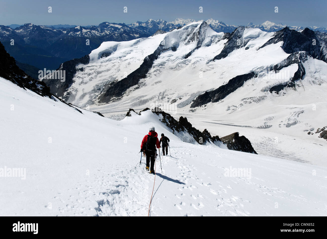 Climbers traveling on a glacier in the Bernese Alps Stock Photo