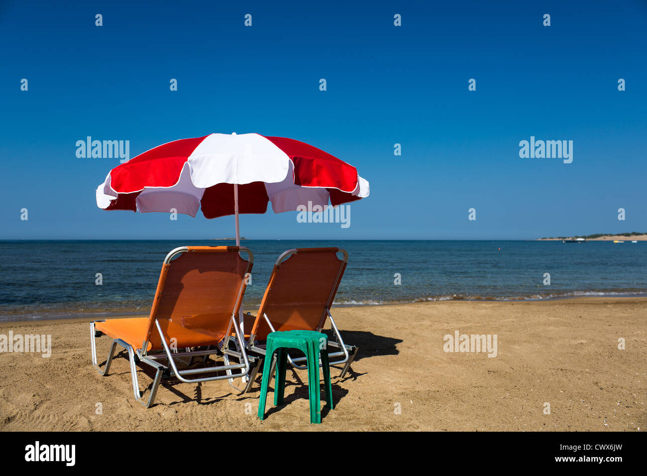 Beach sunbeds with an umbrella on the beach of Agios Georgios, Corfu, Ionian Islands, Greece. Stock Photo