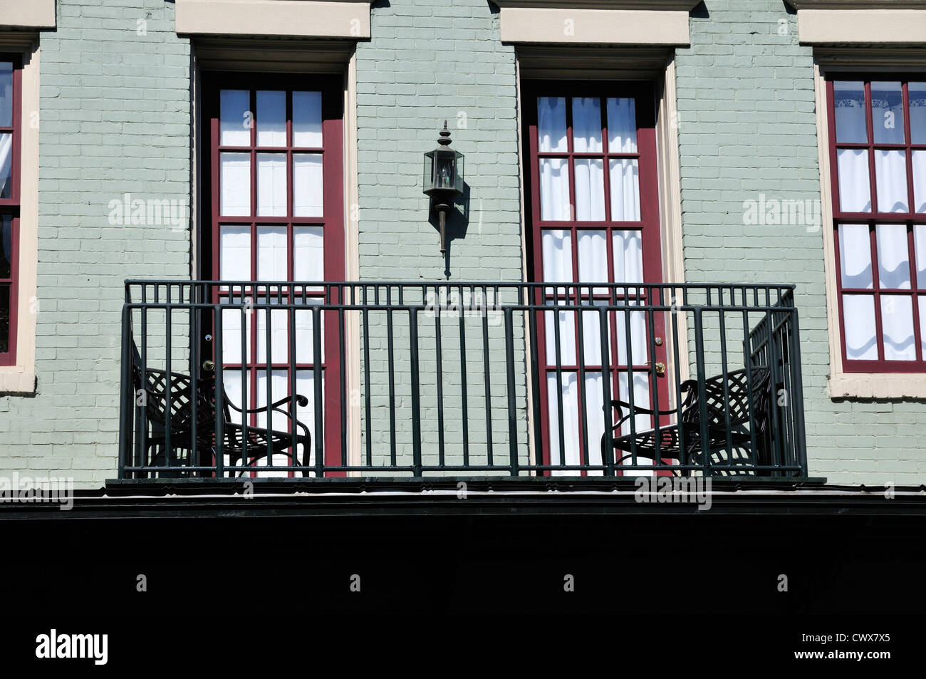 Wrought iron balcony with wrought iron chairs in Mobile, Alabama Stock Photo