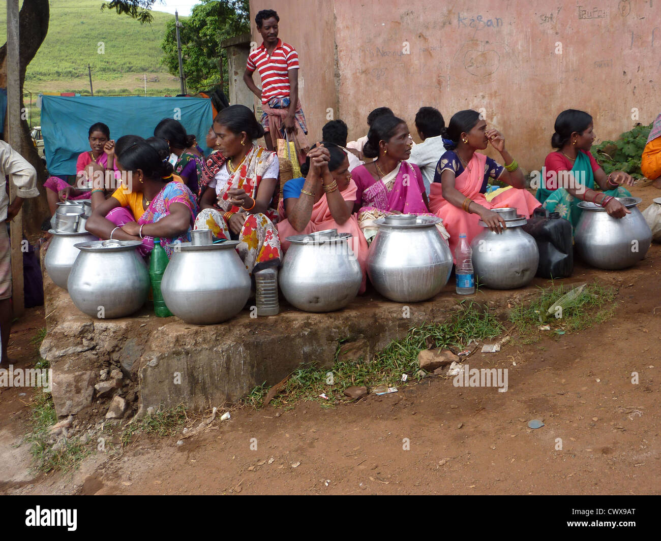 ORISSA, INDIA - Nov 13 - Tribal women sell home brewed liquor from large metal pots on Nov 13, 2009, in Orissa, India Stock Photo