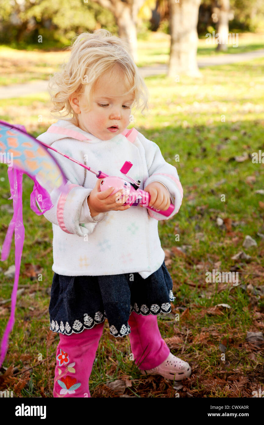 Small girl playing with a pink kite. Stock Photo