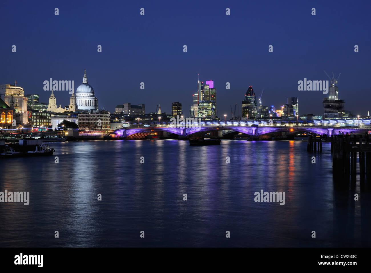 City of London and St Paul's Cathedral floodlit at night, with the River Thames and Blackfriars Bridge Stock Photo