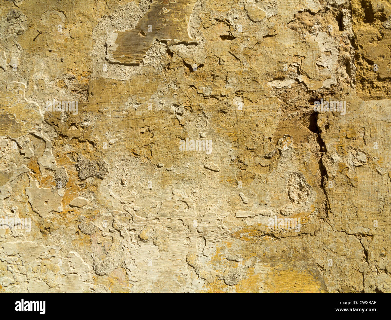 Close up of flaking paint layers and plaster on vertical wall surface Stock Photo