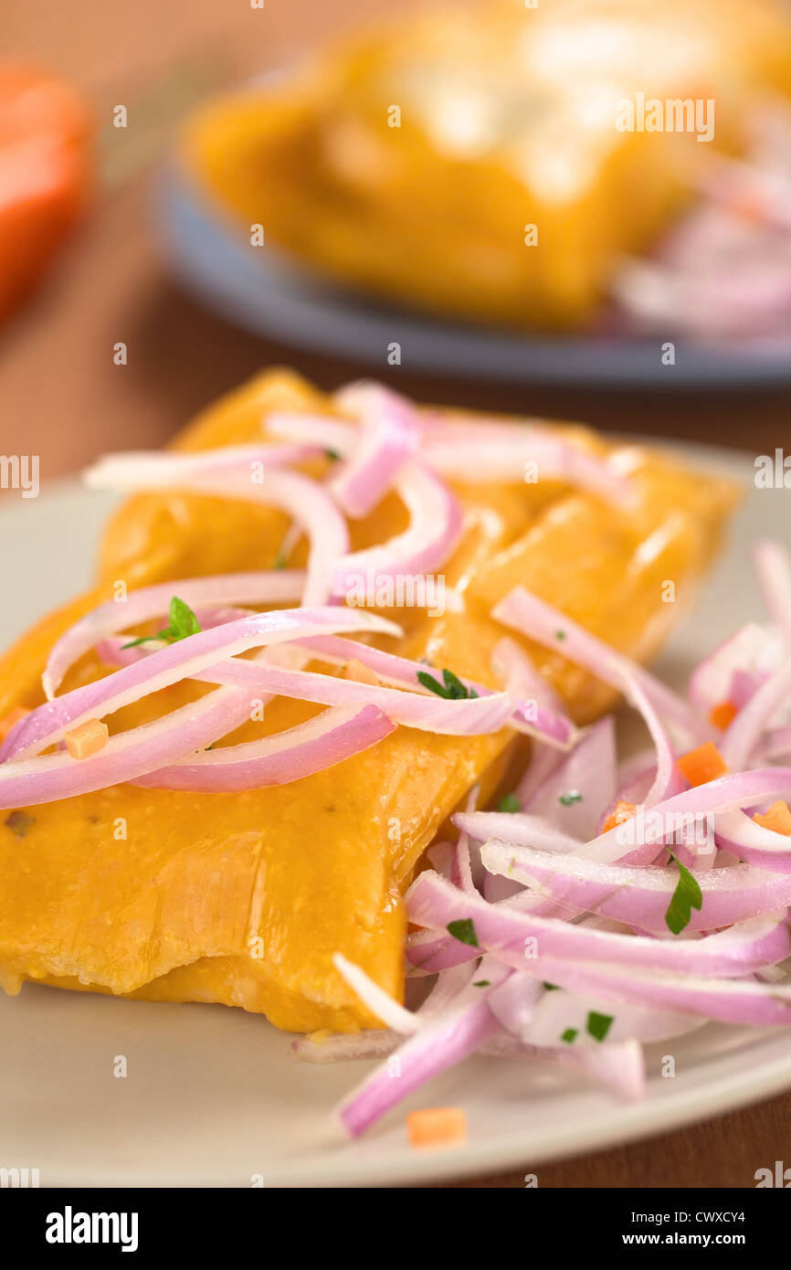 Peruvian tamales (traditionally eaten for breakfast on Sundays) made of corn and chicken and served with salsa criolla Stock Photo