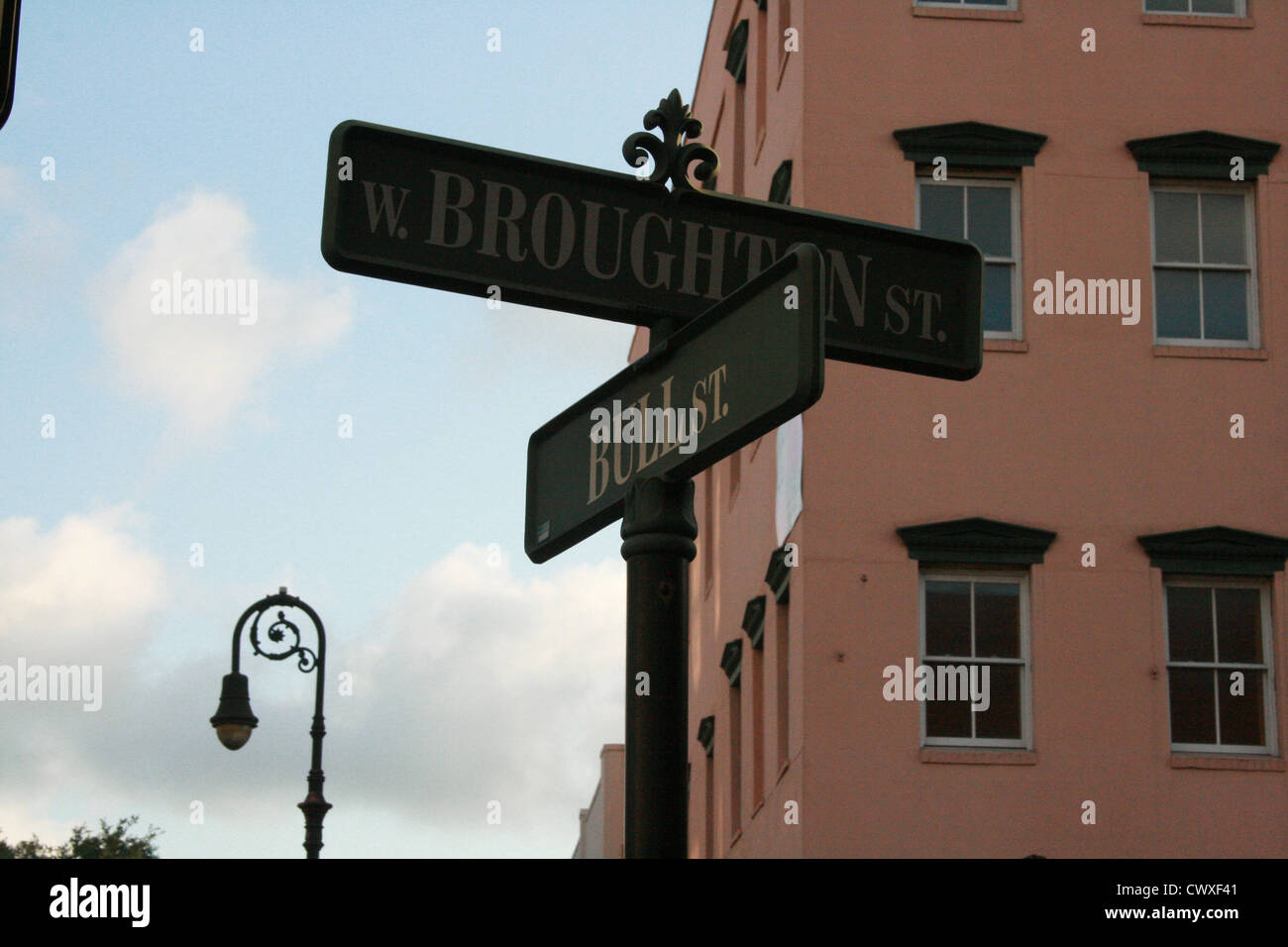 Savannah Georgia GA road sign Broughton and Bull Street intersection with old antique light pole and cityscape architecture Stock Photo