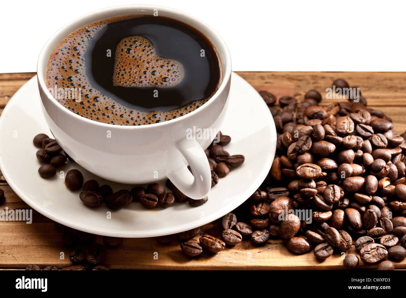 Coffee cup and saucer on a wooden table. Foam in the form of the heart. Stock Photo