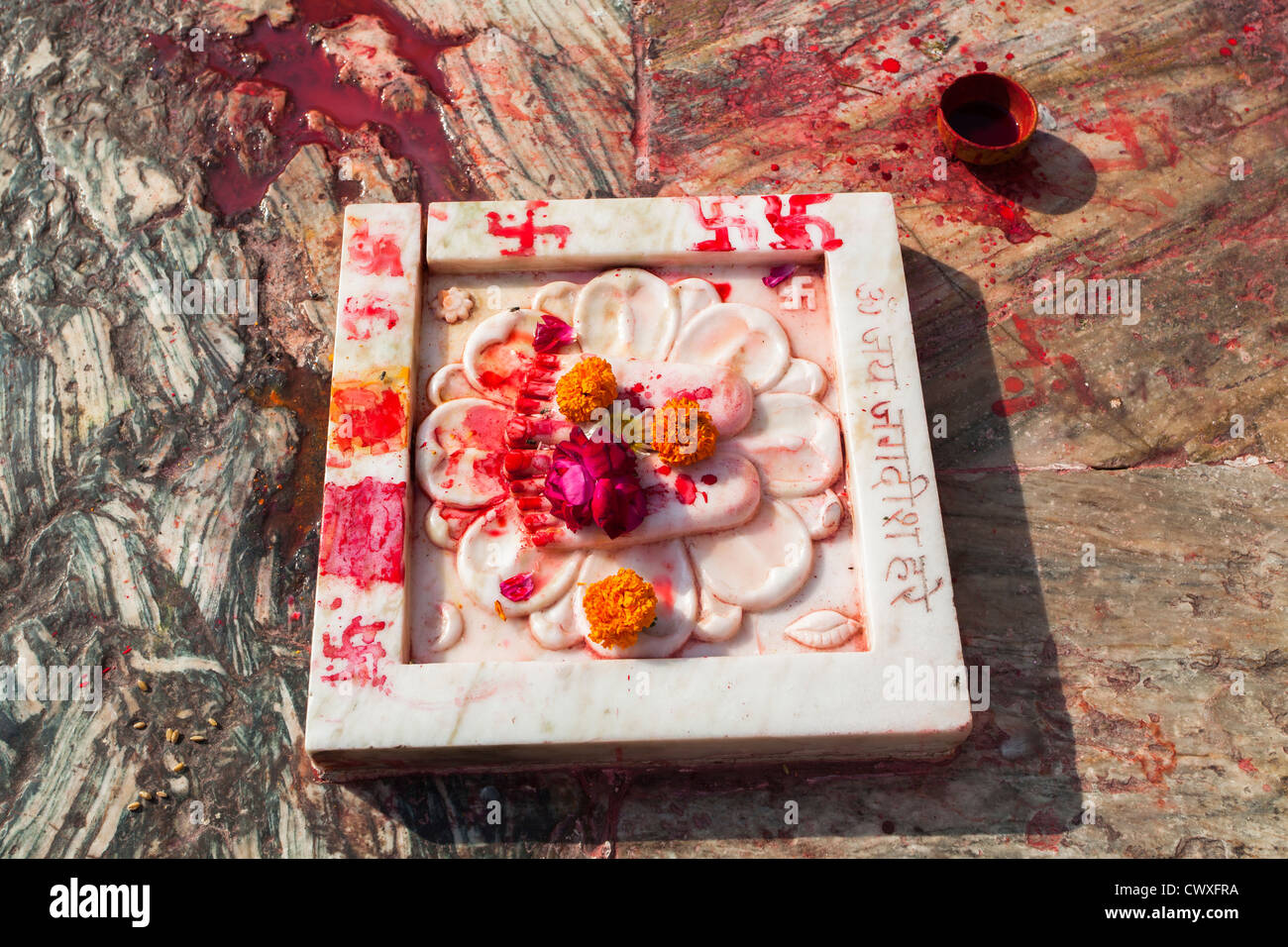 Hindu religious devotion objects in temple, Udaipur, India with finger-painted swastikas Stock Photo