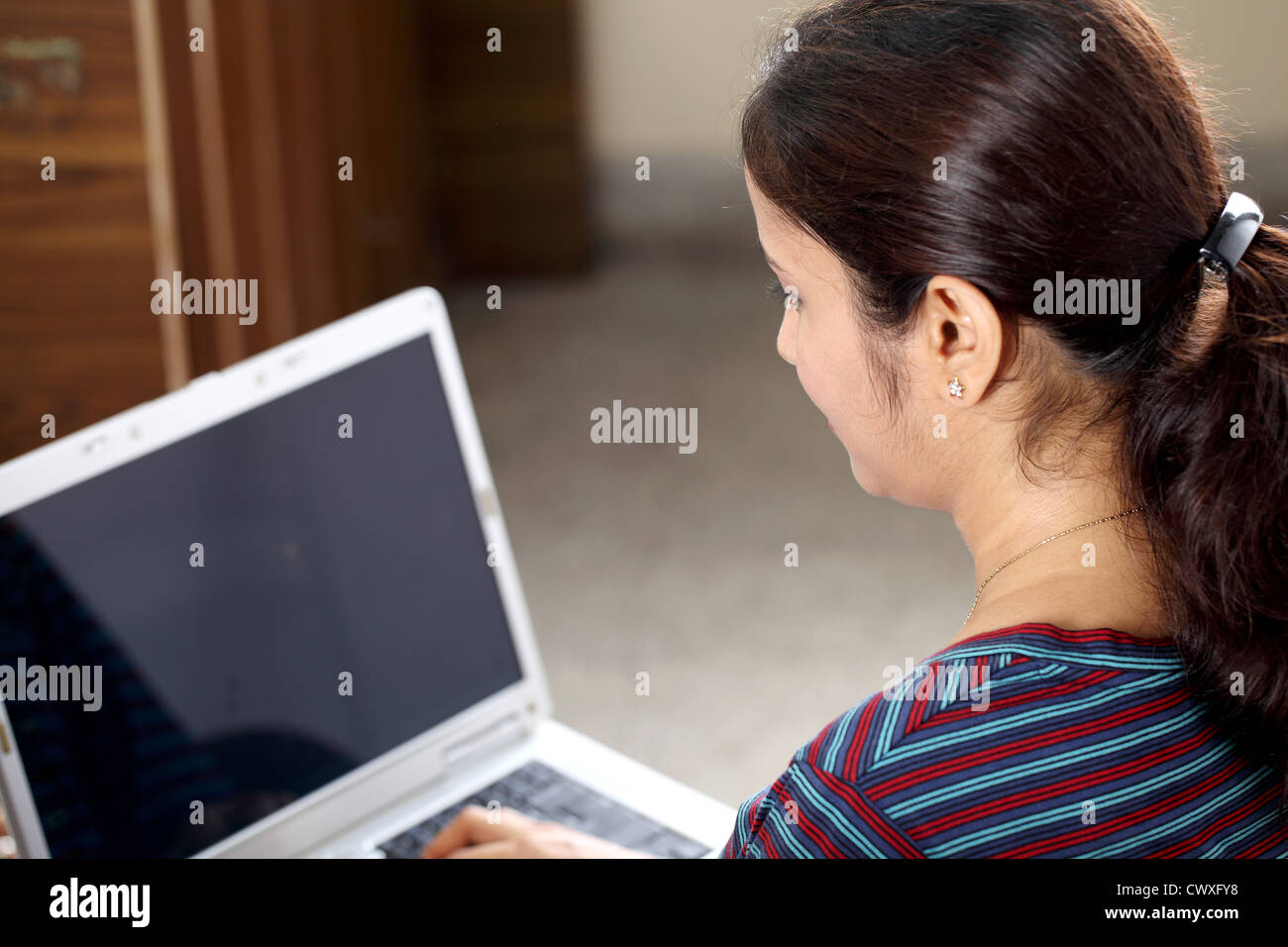 Young Indian woman browsing internet from home Stock Photo - Alamy