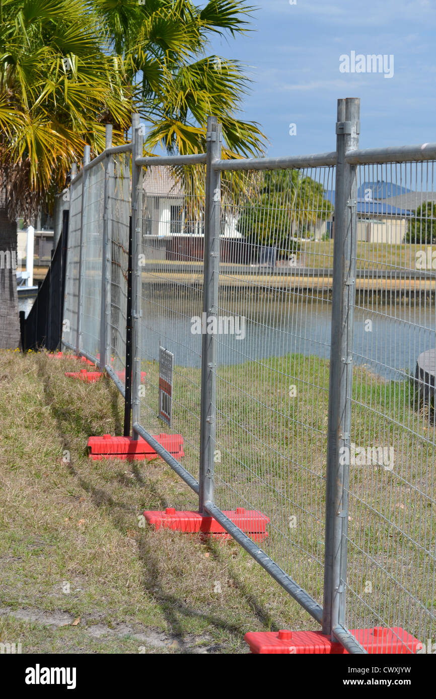 Temporary fence surrounding a construction site on a block of land next to a canal Stock Photo