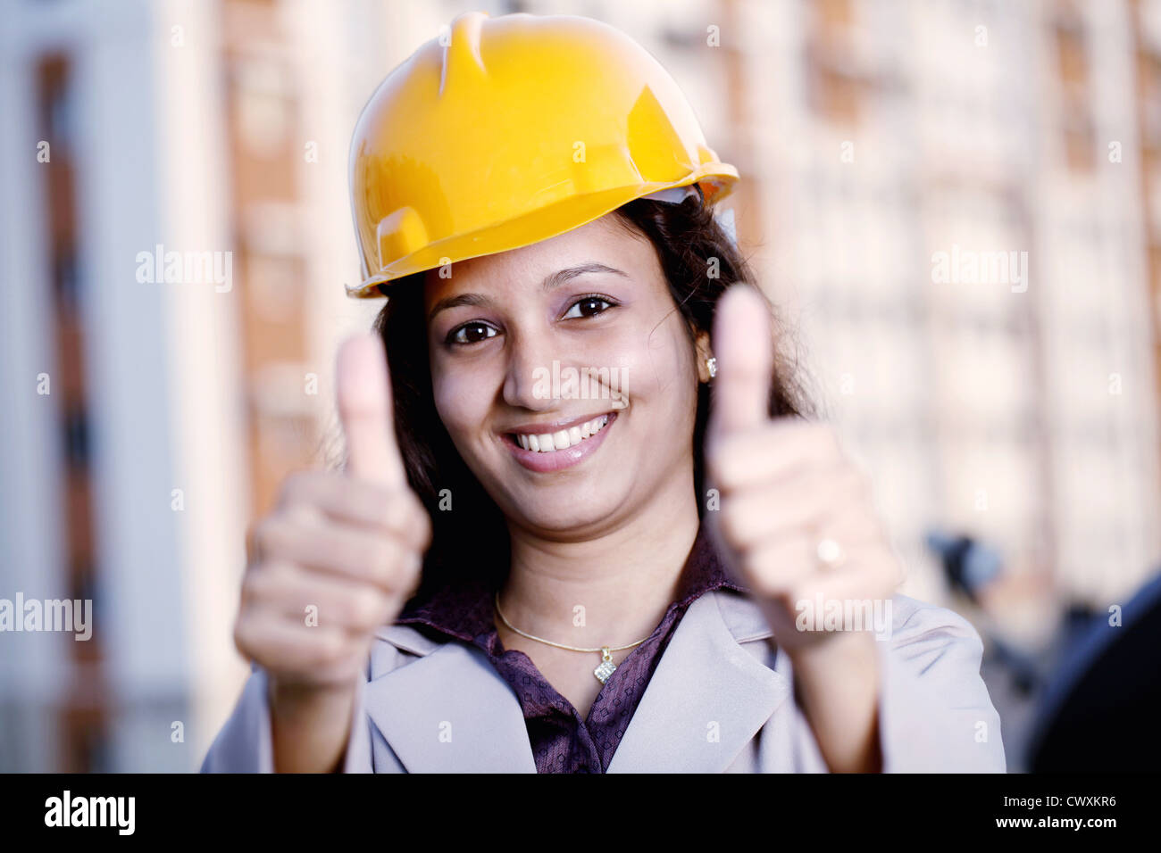 Happy young Indian female industrial engineer with thumbs up gesture Stock Photo