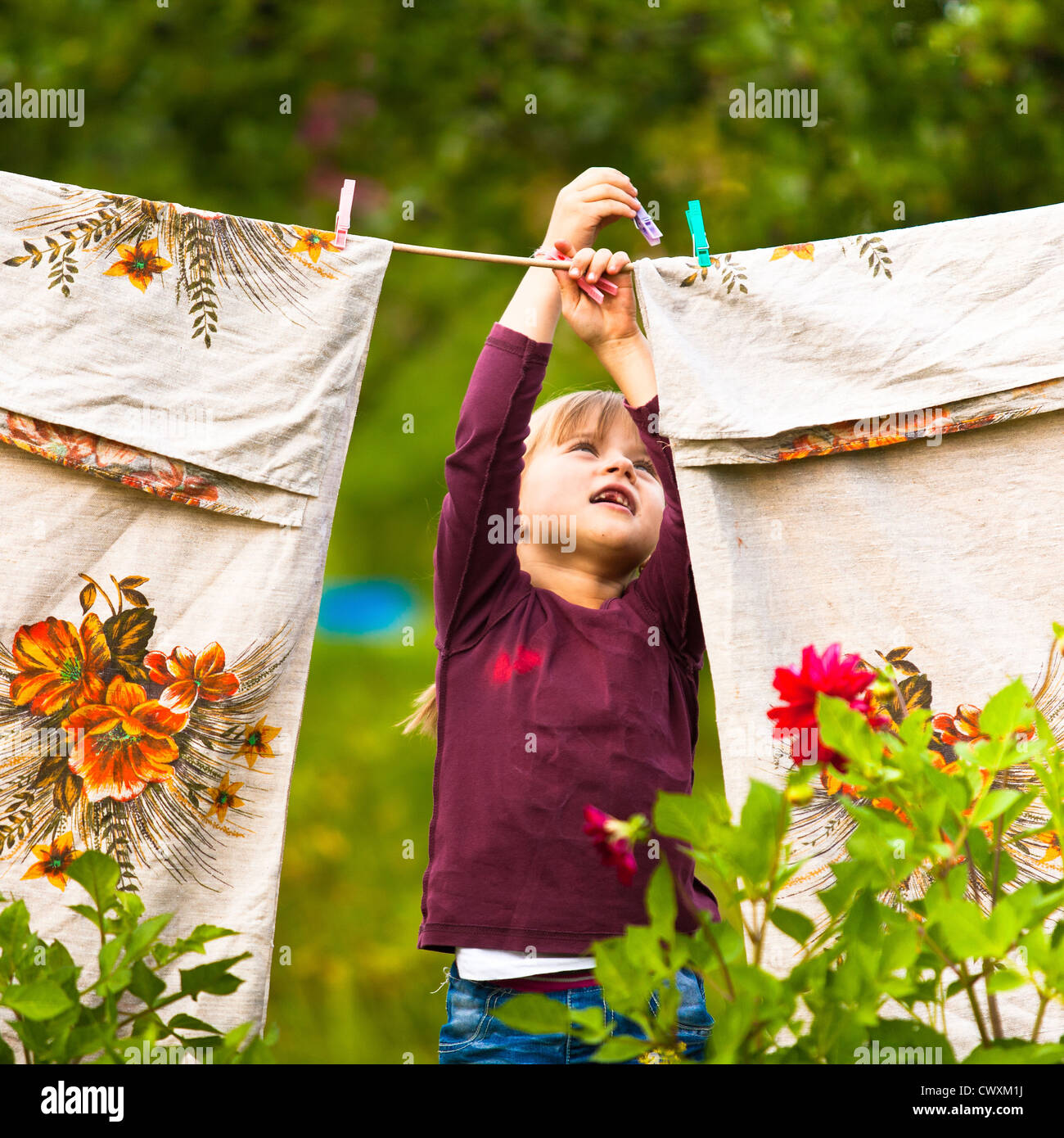 Sweet five-year girl with clothespin and the clothesline Stock Photo