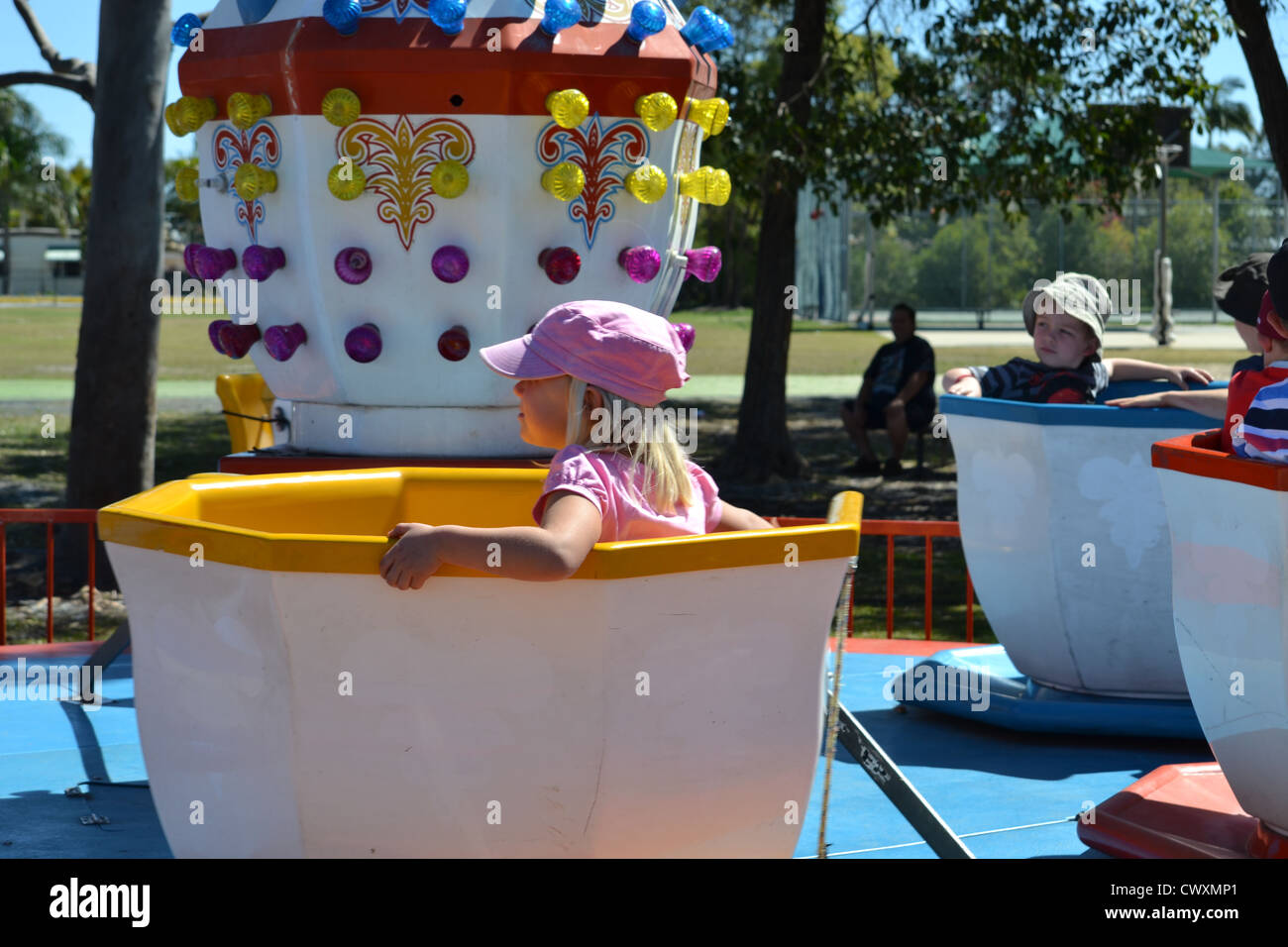 young children on the Cup and Saucer ride at a school fete / fair Stock