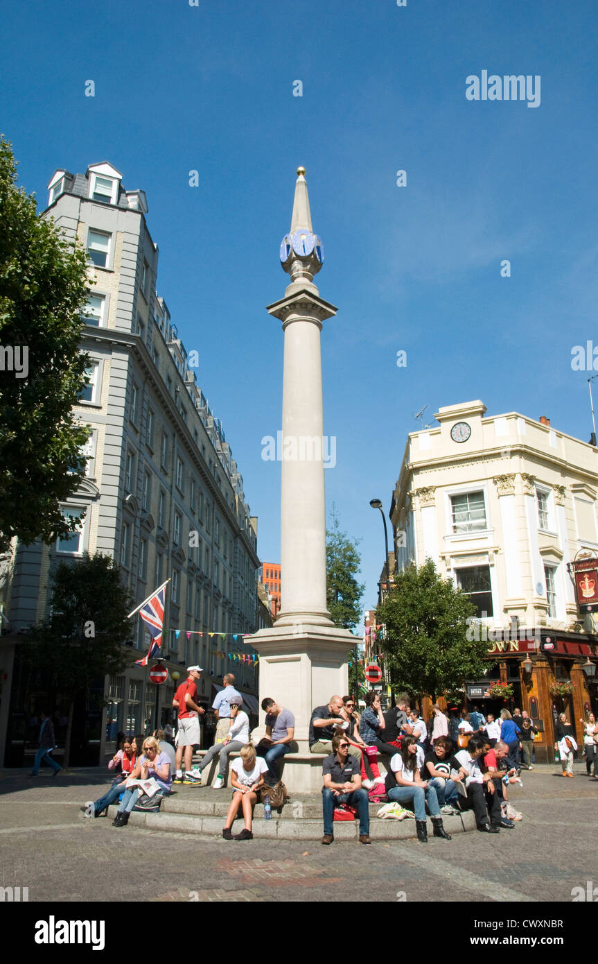 Sundial pillar with people sitting below at Seven Dials in Covent Garden where 7 streets converge Stock Photo