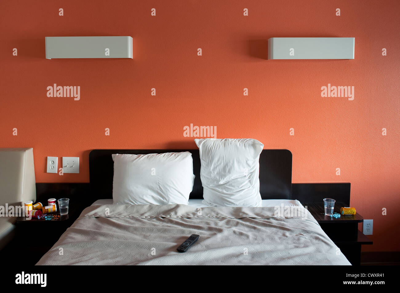 Motel room with bed and medications on side table near bed with tv