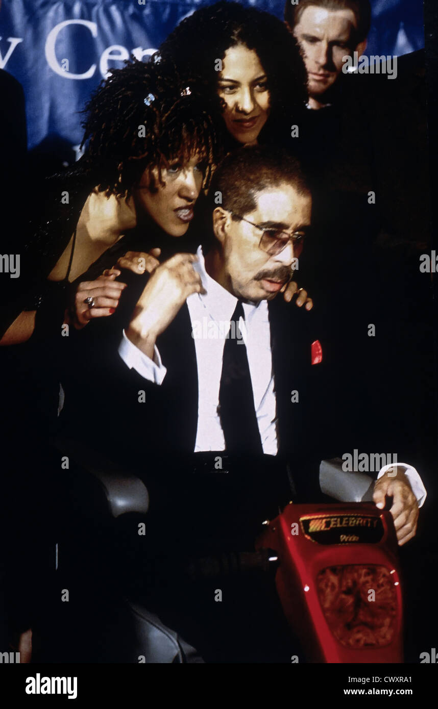 Comedian Richard Pryor, seated, receives the Mark Twain Comedy Award as family members look on at the Kennedy Center October 20, 1998 in Washington, DC (L-R) Daughters Rain Pryor and Elizabeth Pryor. Stock Photo