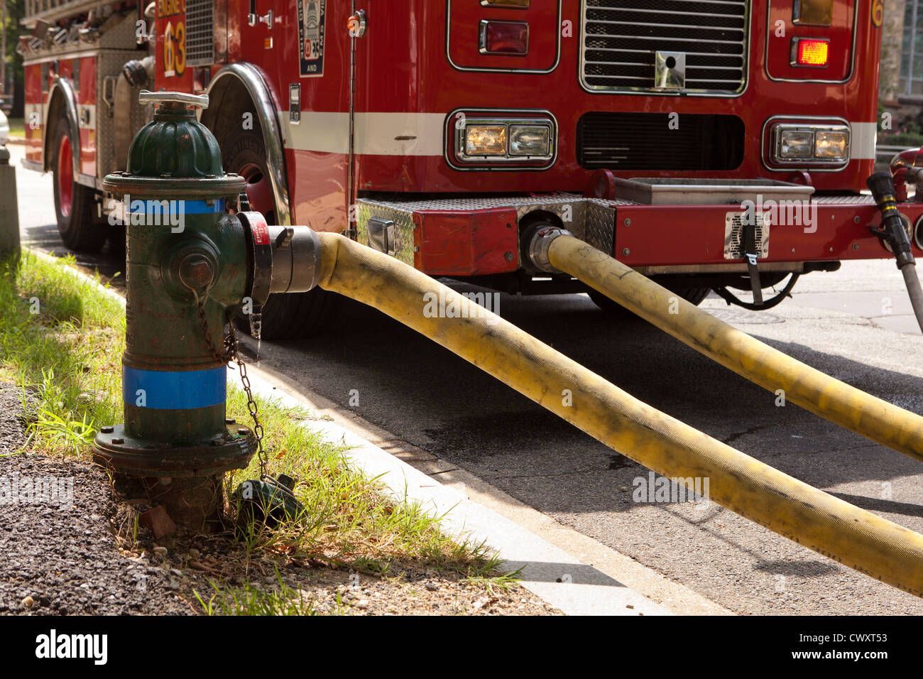 Firetruck hose mounted on hydrant Stock Photo