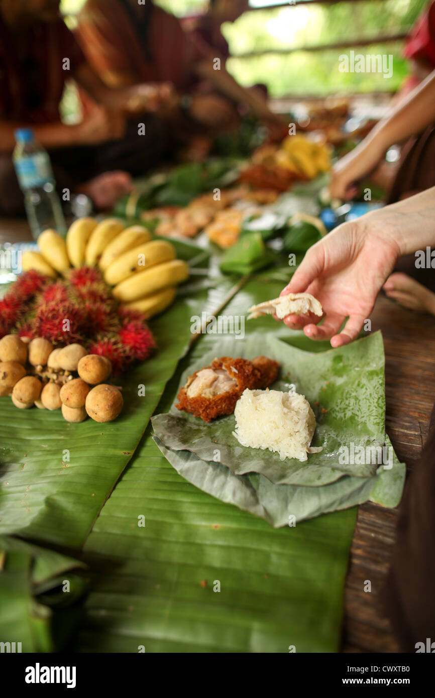 CHIANG MAI, THAILAND - June 16, 2012: Traditional Thai food of sticky rice and pork, dessert, fruits, warpped in banana leaves. Stock Photo