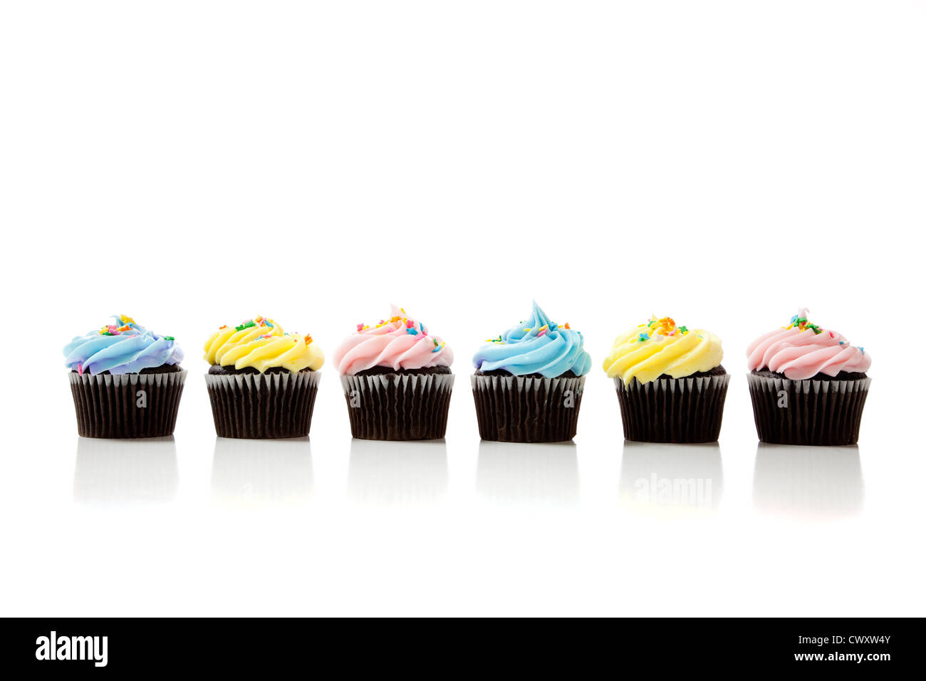 A row of lightly colored chocolate cupcakes on a white background Stock Photo