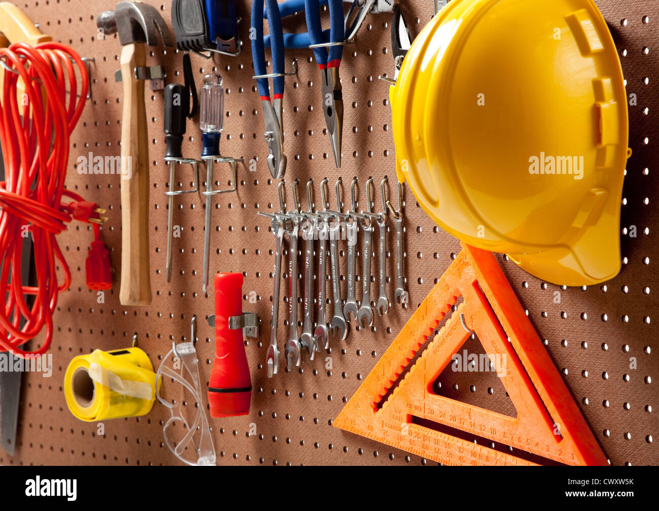 A pegboard with various tools such as hammer, saw, wrenches