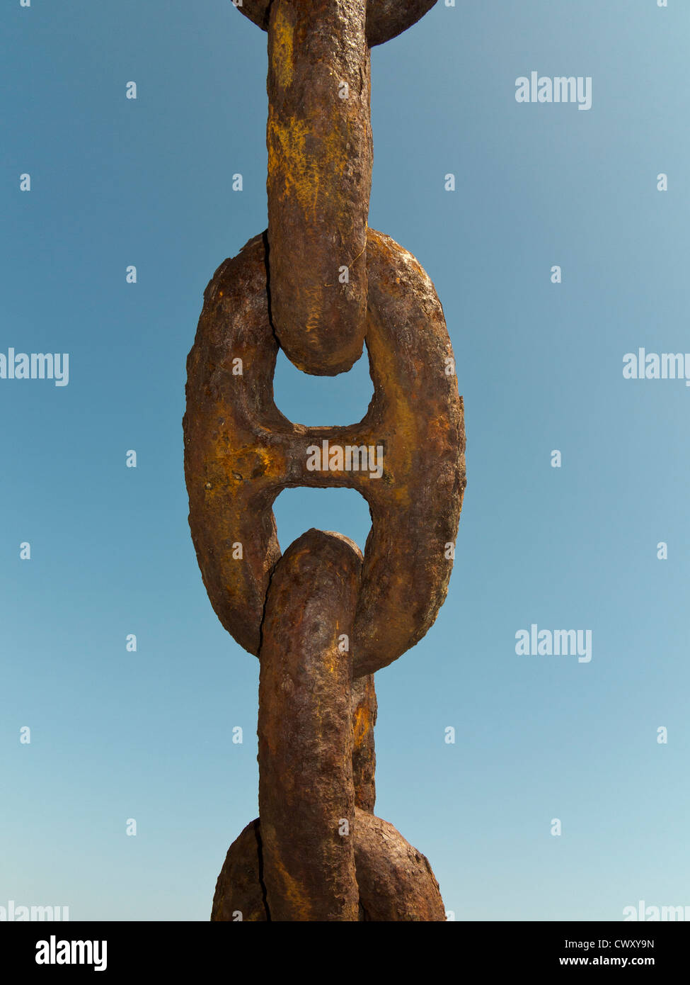 Close up of large rusted anchor chain links against a blue sky Stock Photo
