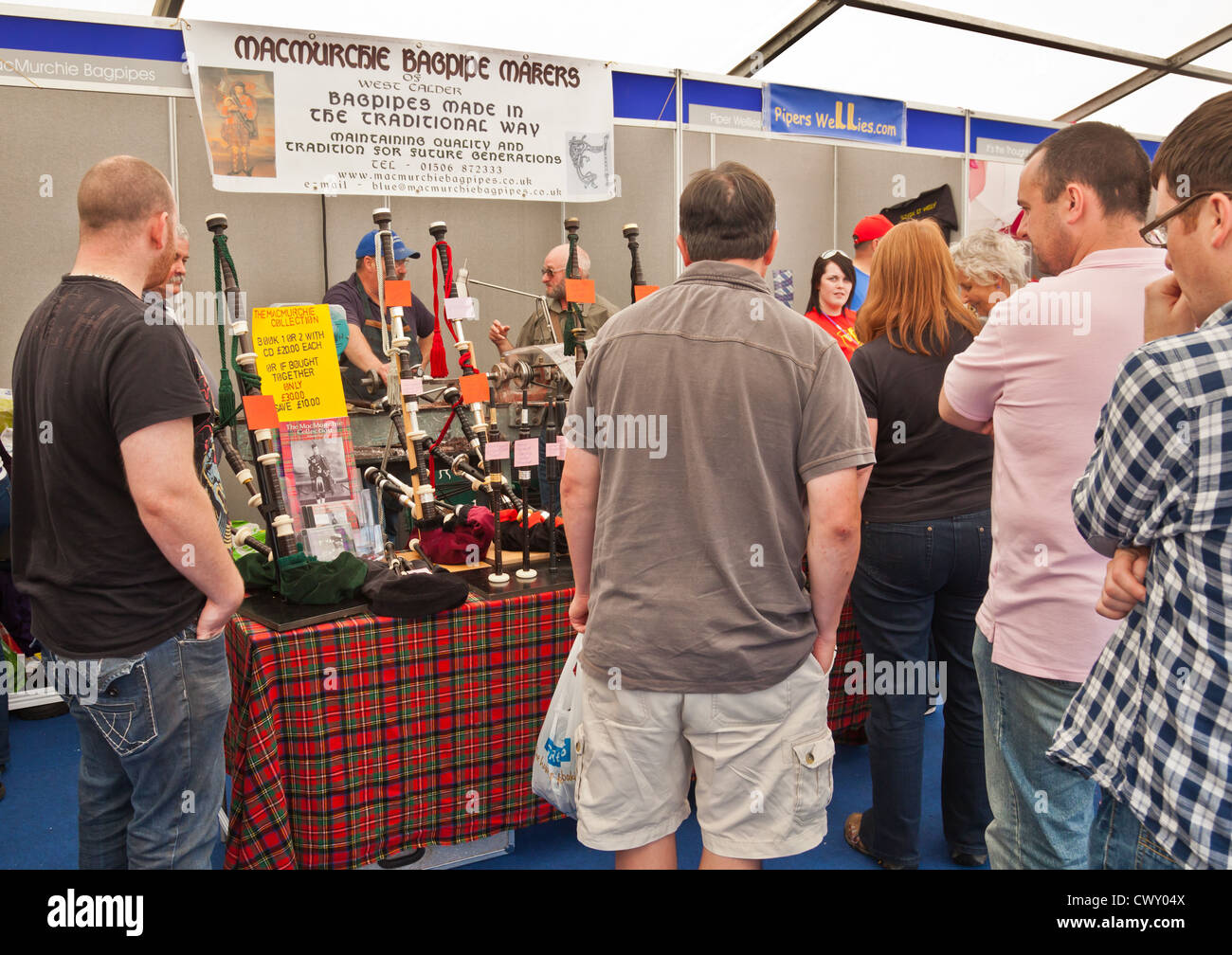 Members of the public looking at a stall promoting bagpipes by Macmurchie Bagpipe Makers. Piping Live! festival, Glasgow. Stock Photo