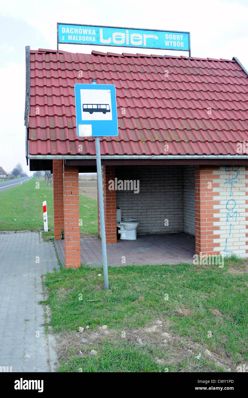 A bus stop shelter with an old toilet bowl placed there as a joke. Stock Photo