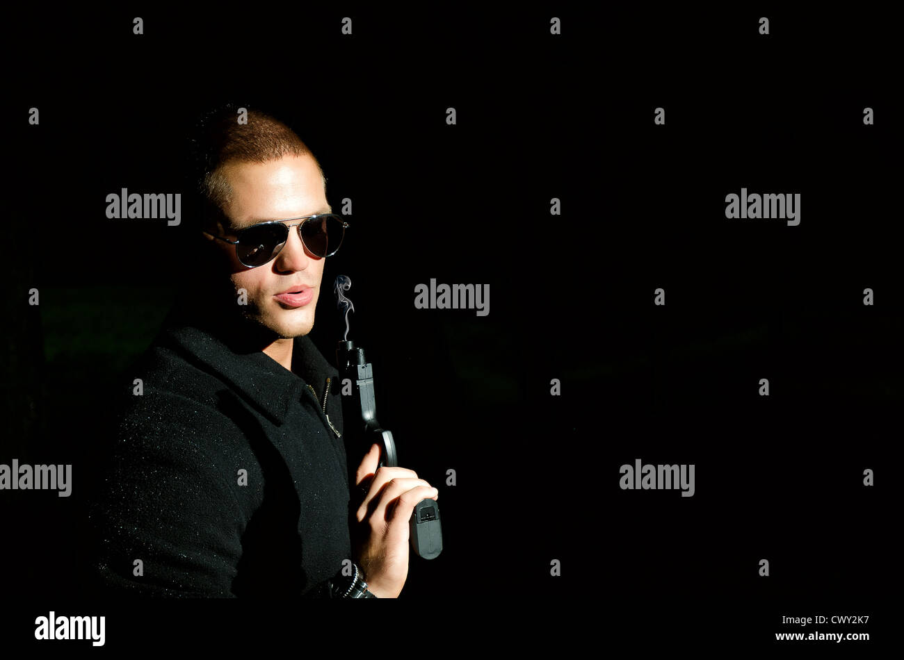 Portrait of young man with gun Stock Photo - Alamy