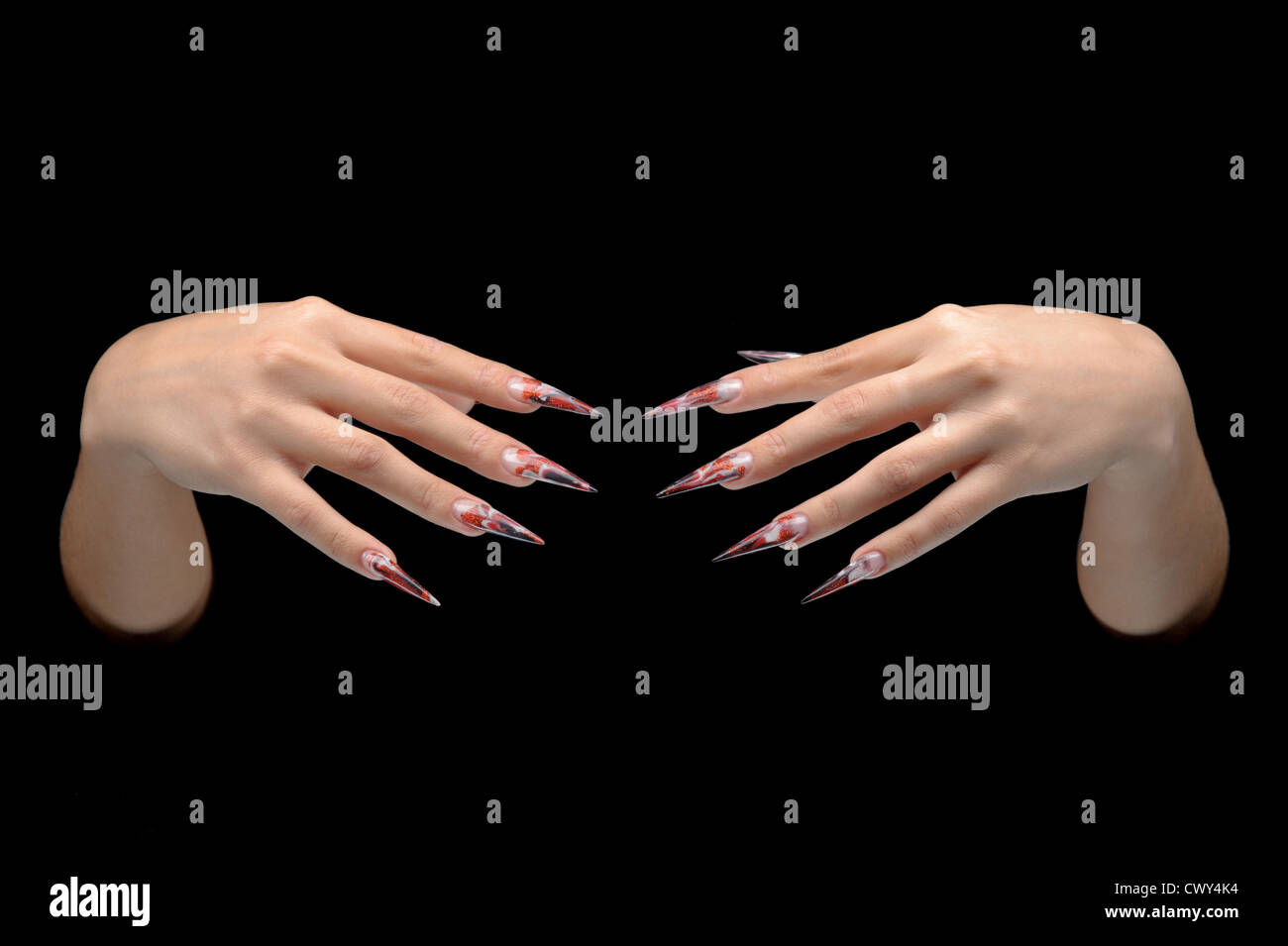 Closeup of hand of young woman long nail-art manicure on nails isolated on black Stock Photo