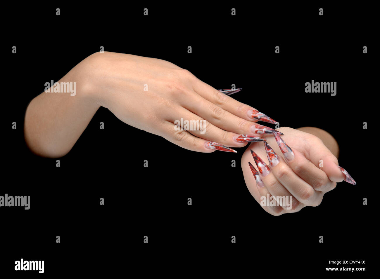 Closeup of hand of young woman long nail-art manicure on nails isolated on black Stock Photo