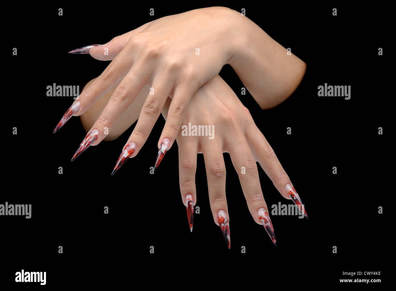 Closeup of hand of young woman long nail-art manicure on nails isolated on black Stock Photo