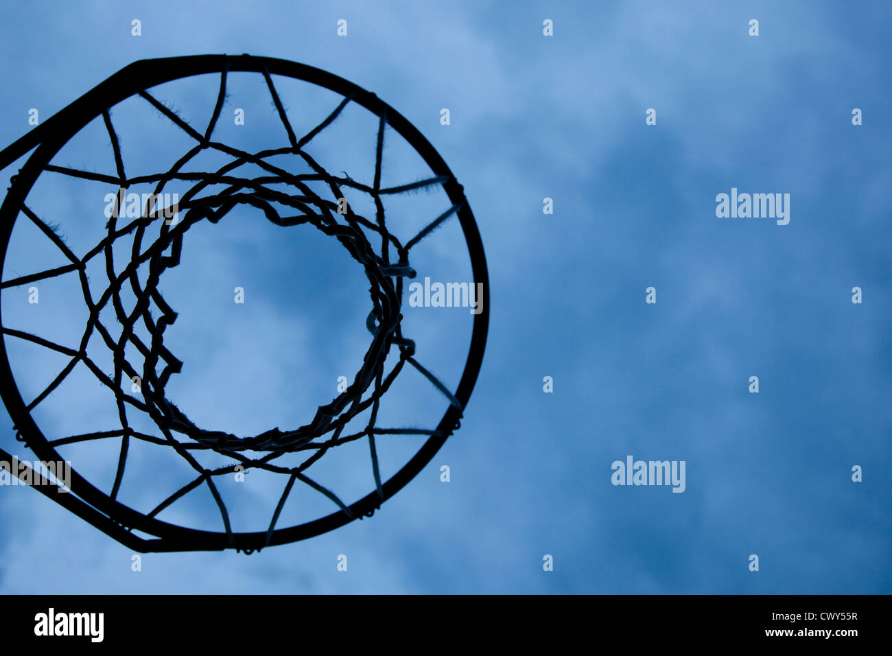 A basketball hoop and net with a cloudy blue sky background Stock Photo