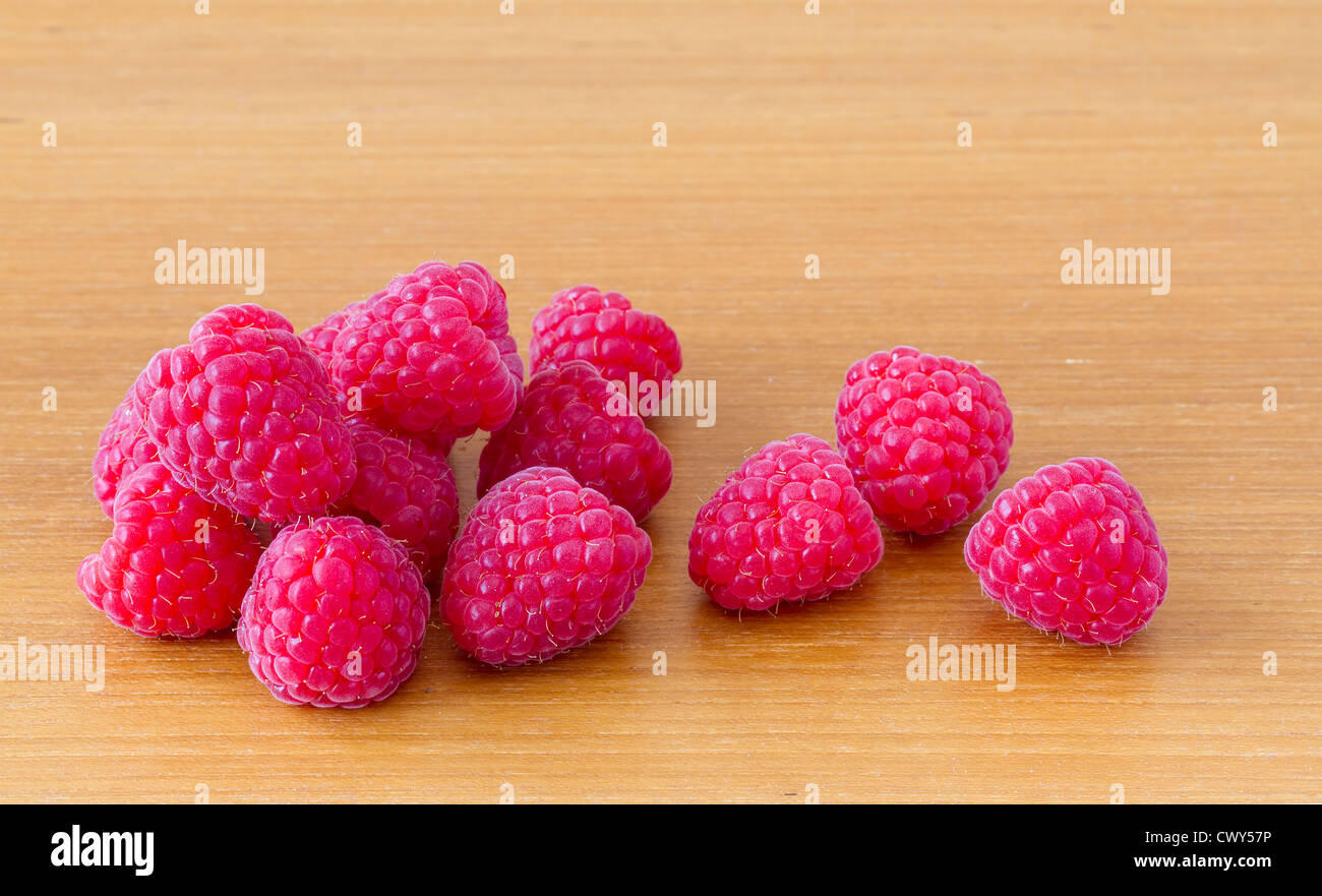 Red ripe raspberries on wooden table Stock Photo