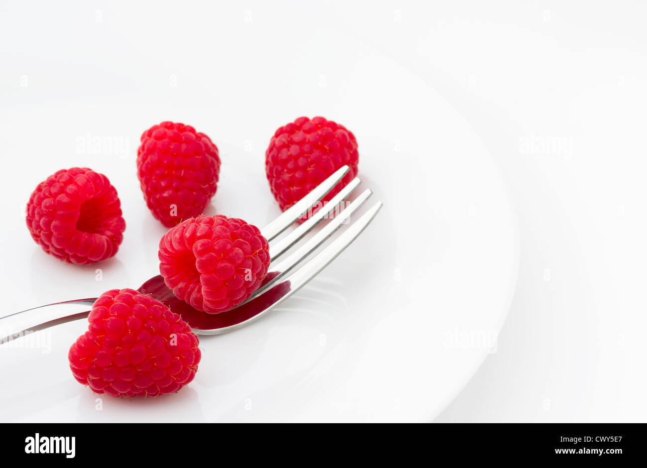 Red ripe raspberries on a plate Stock Photo