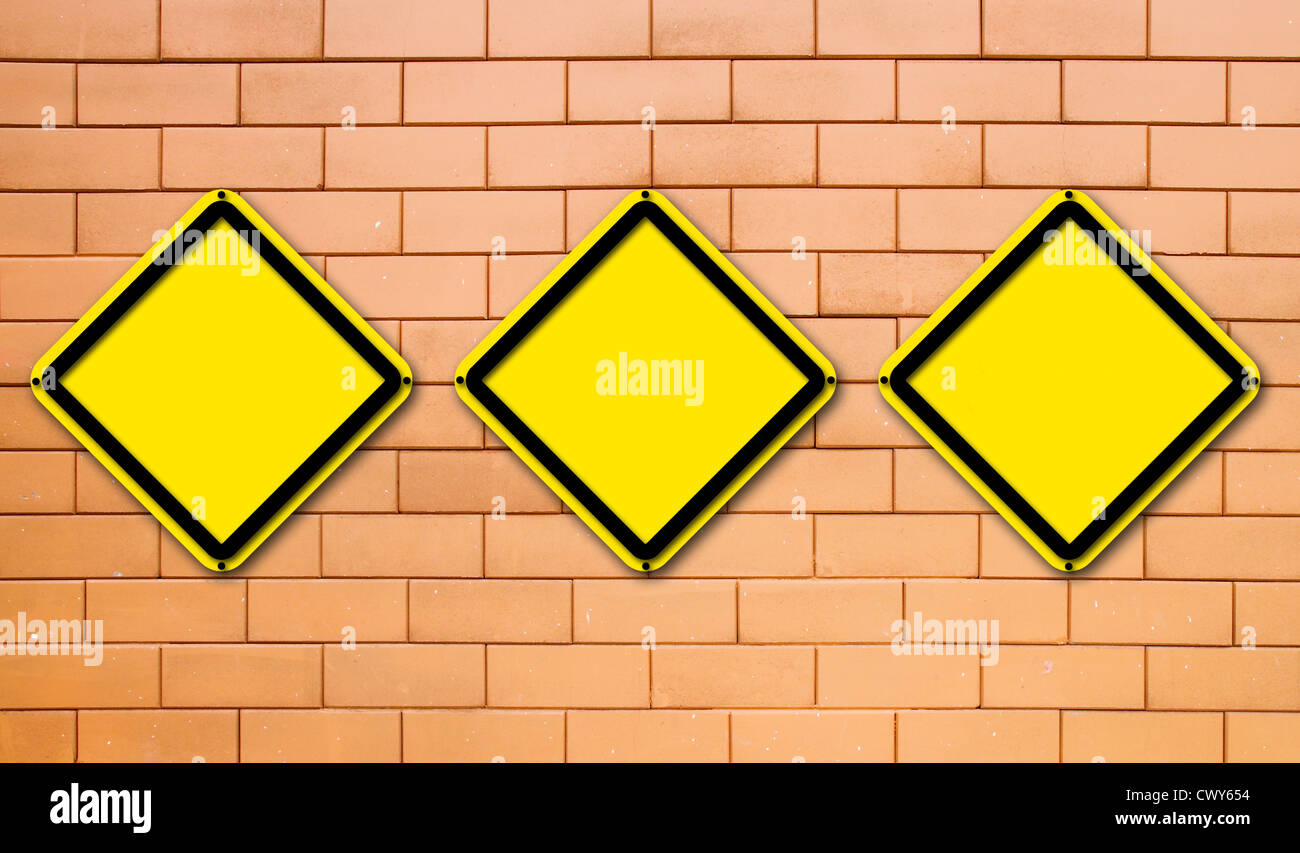 Three blank yellow traffic sign on brick wall background Stock Photo ...
