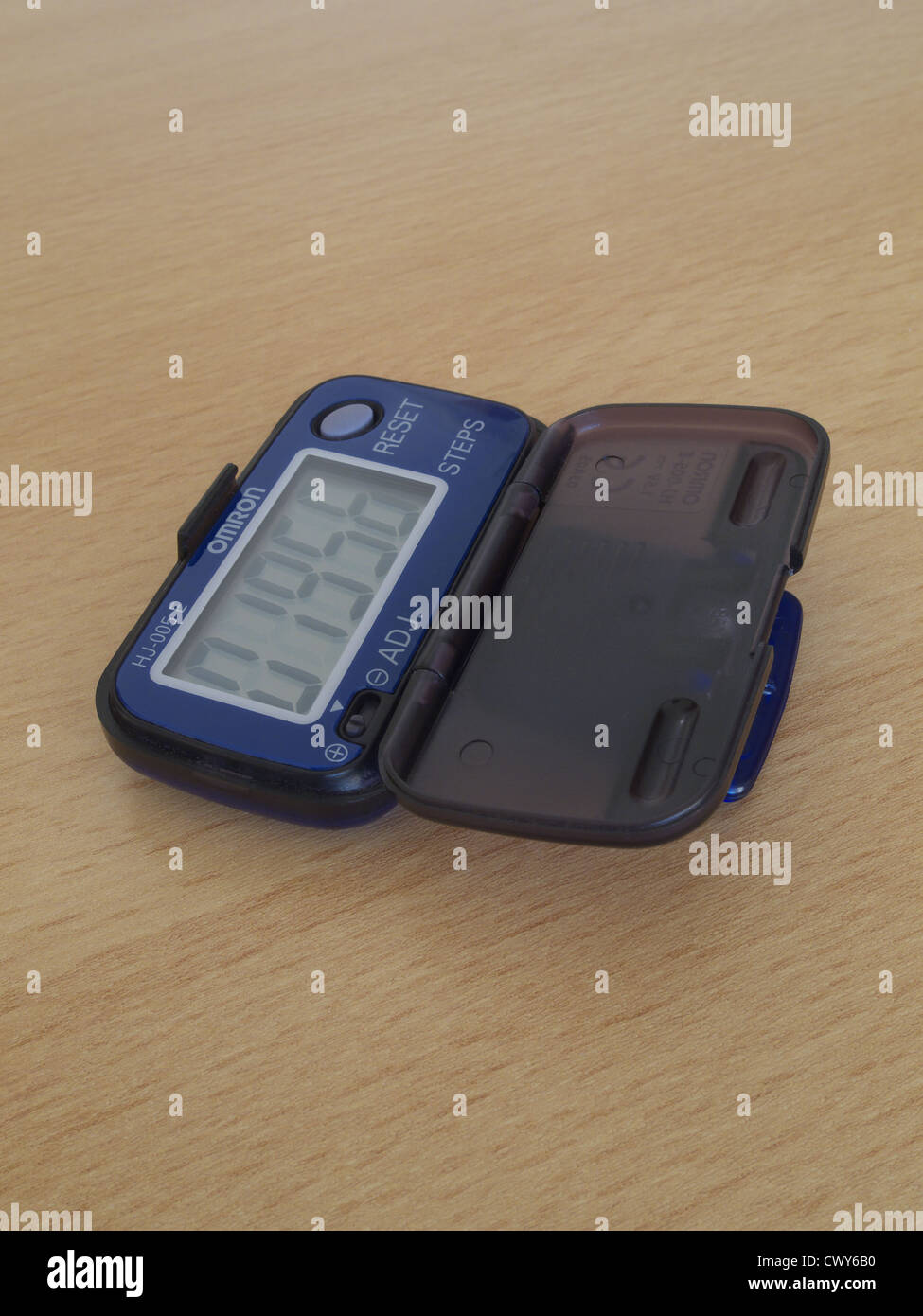 A Digital Pedometer Showing it's LCD Display on a Wooden Background ...