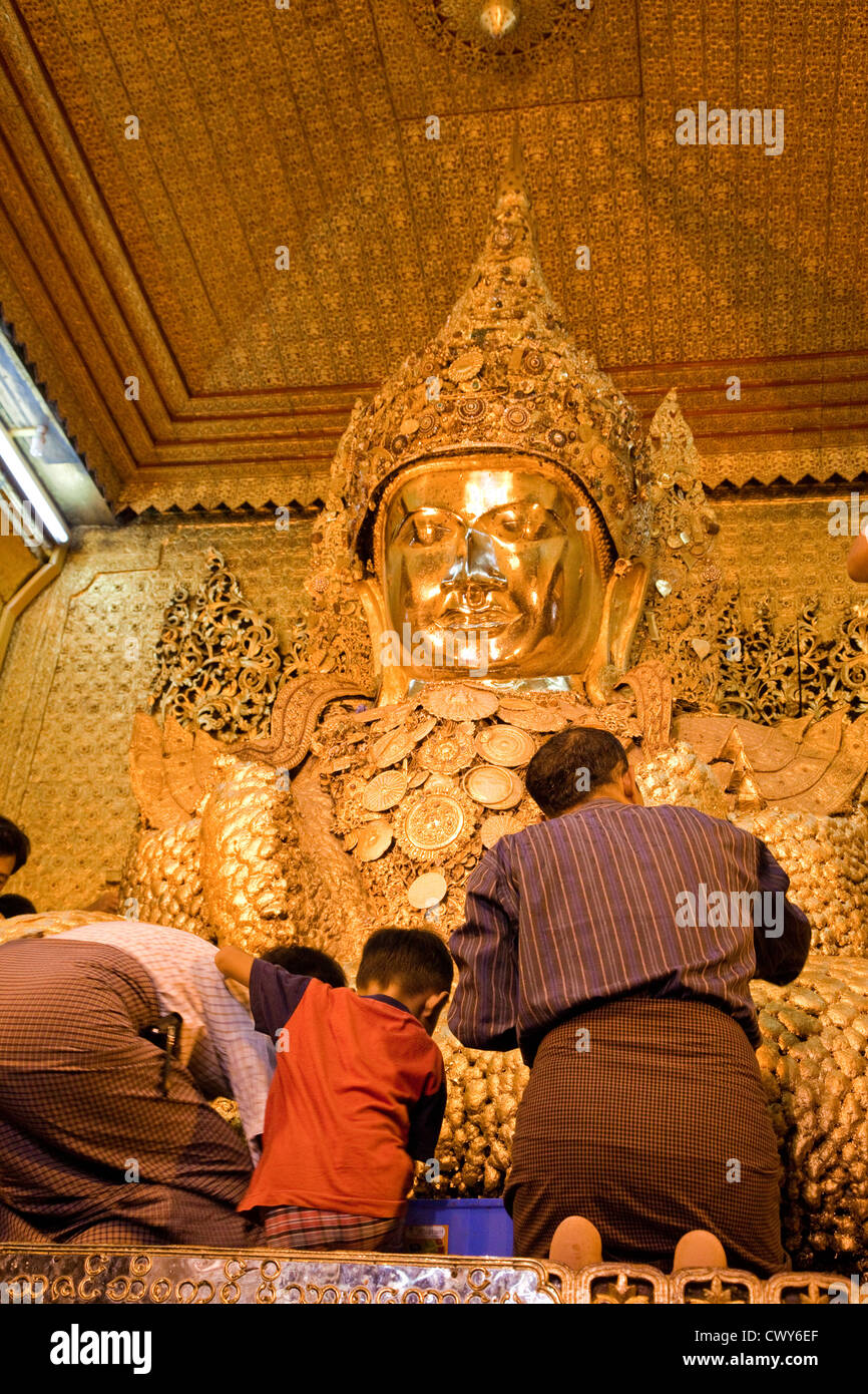 Myanmar, Burma. Mandalay. Mahamuni Buddhist Temple. Men and boys apply