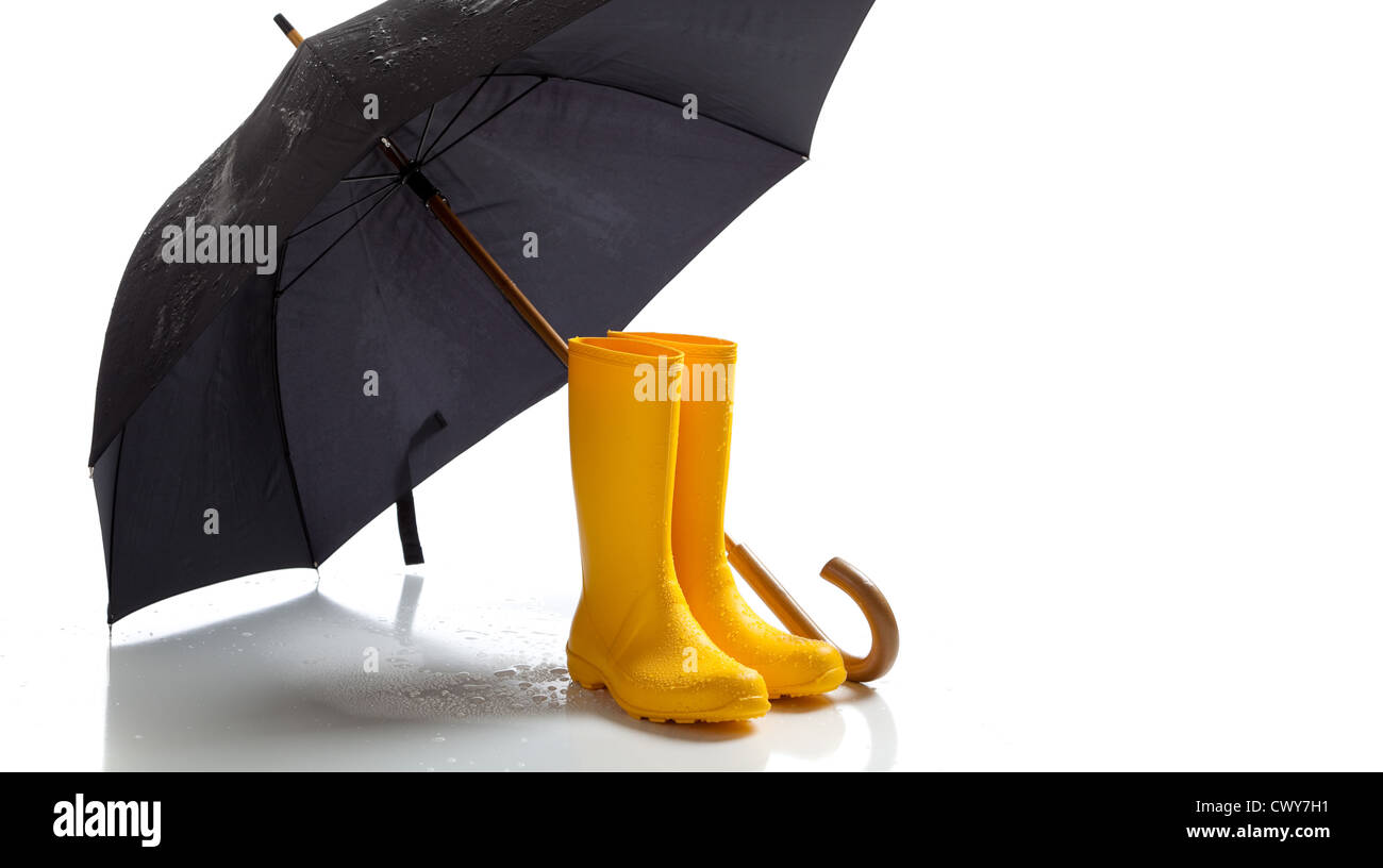 A pair of yellow rain boots and a black umbrella on a white background