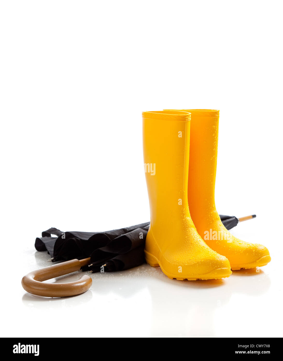 A pair of yellow rain boots and a black umbrella on a white background