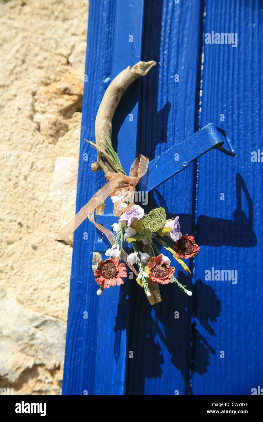 Flowers tied to a blue shutter, France Stock Photo