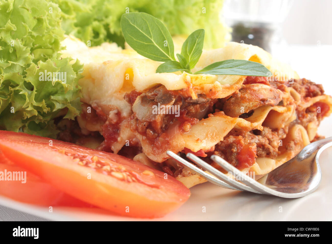 A slice of meat lasagna with a side salad. Stock Photo