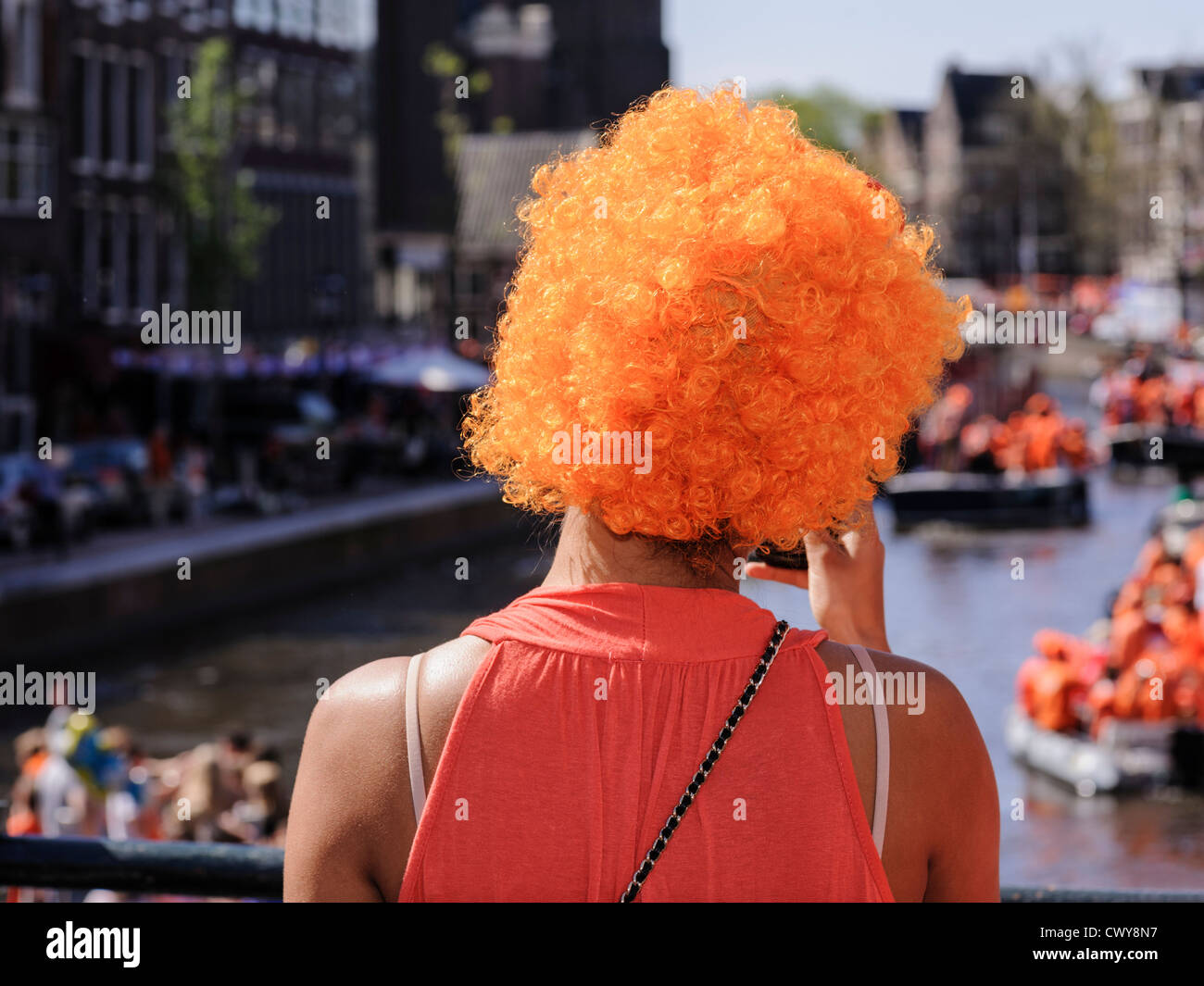 Young woman wearing an orange wig, Amsterdam, Netherlands Stock Photo