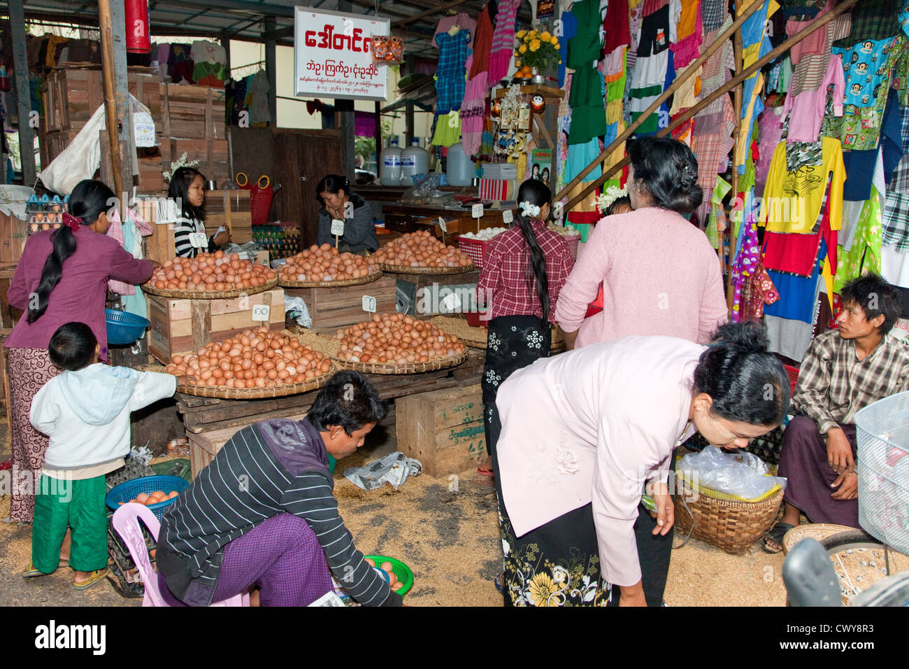 Myanmar, Burma. Mandalay Market, Stall Selling Eggs and Clothing. Stock Photo