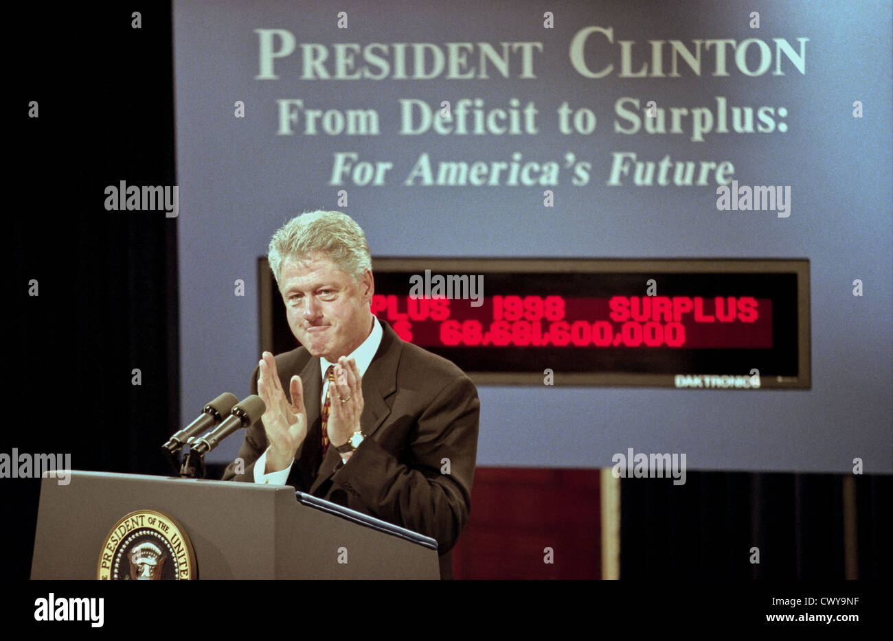 US President Bill Clinton standing in front of the new Budget Surplus