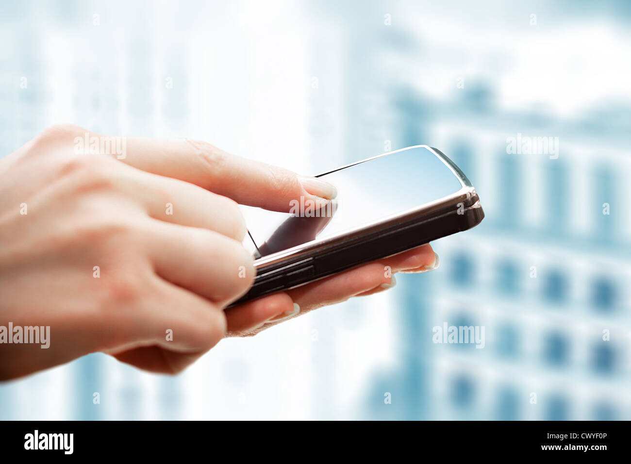 Closeup of female hands using a smart phone. City background. Stock Photo